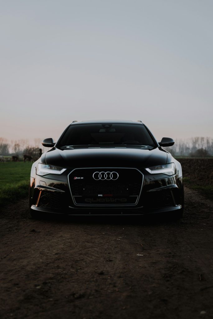 Đầu xe Audi màu đen đứng trên bãi cỏ lúc chạng vạng