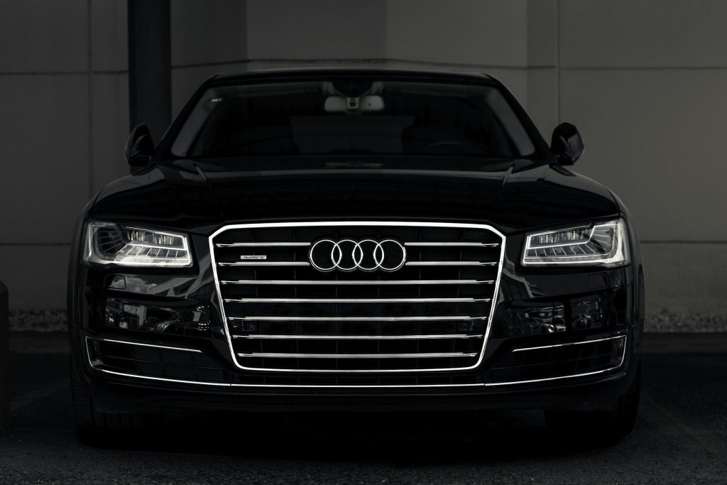 Đầu xe Audi A8 màu đen với lưới tản nhiệt lớn, nền tối