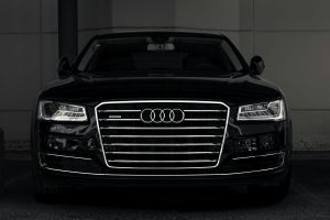 Đầu xe Audi A8 màu đen với lưới tản nhiệt lớn, nền tối
